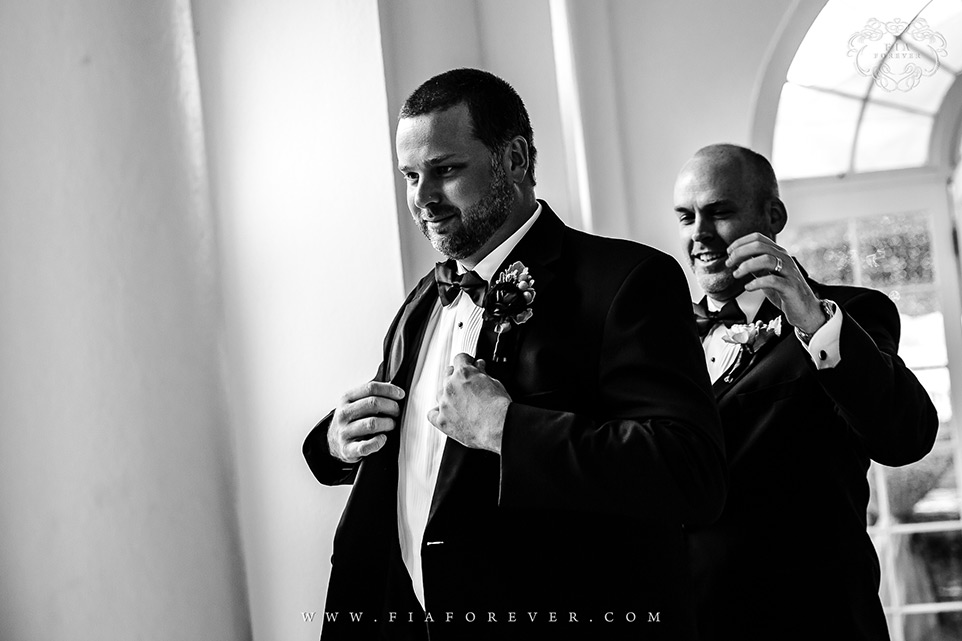 Best man helping groom put on jacket Lowndes Grove Plantation WeddingPhoto by Charleston Wedding Photographers Fia Forever